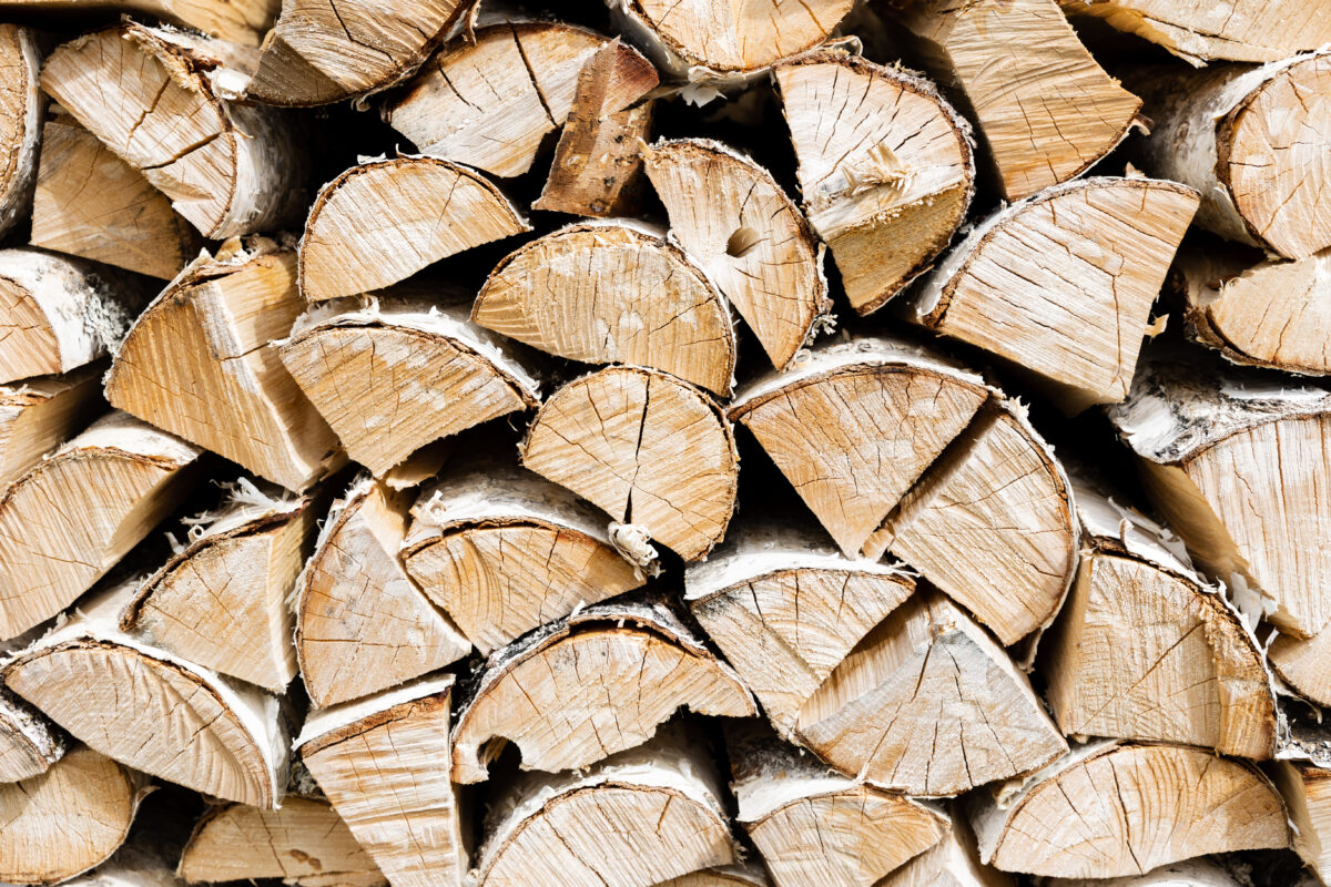 Firewood background. Dry chopped wooden logs. Natural texture.
